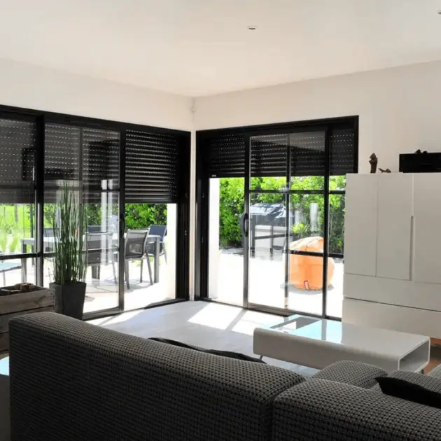Baie vitrée aluminium avec volet intégré pour un intérieur moderne.