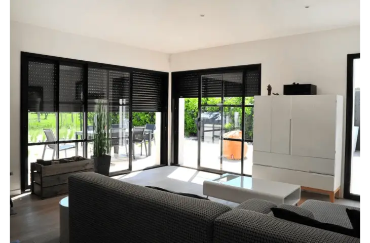 Baie vitrée aluminium avec volet intégré pour un intérieur moderne.