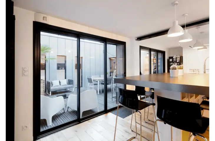 Baie vitrée aluminium noire dans un intérieur contemporain.