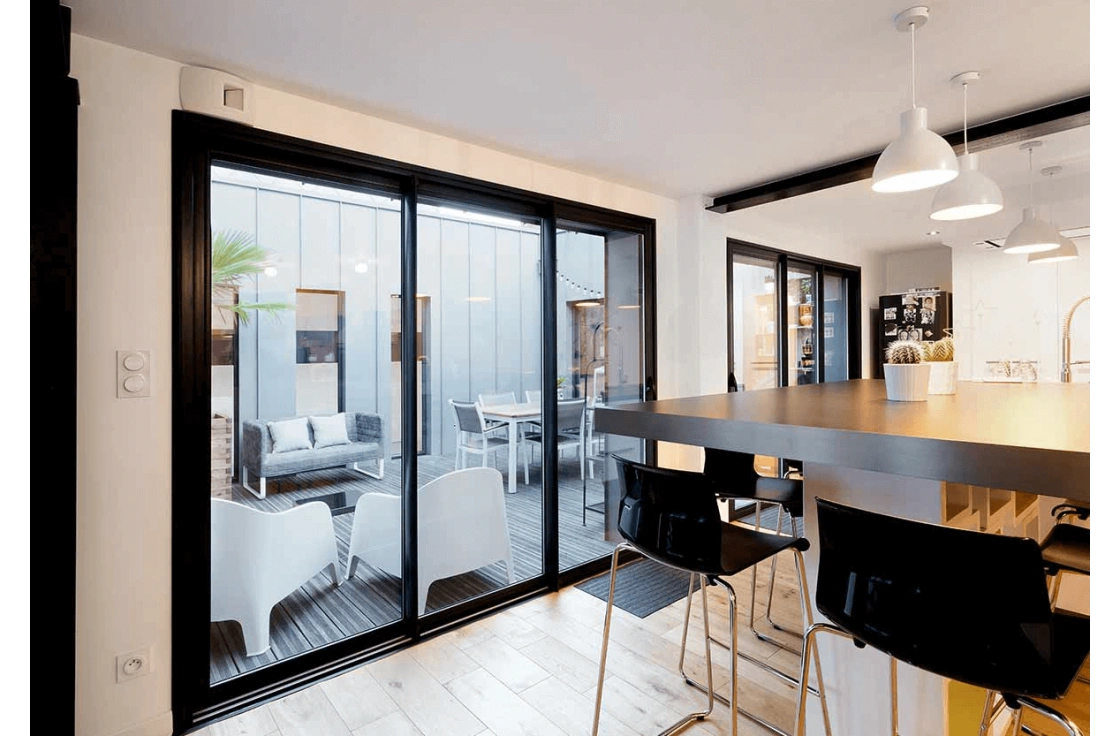 Baie vitrée aluminium noire dans un intérieur contemporain.