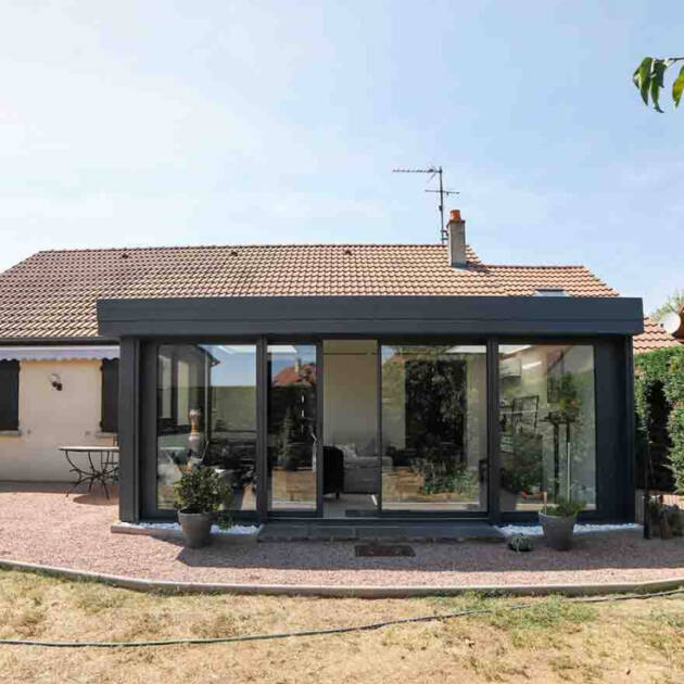 Véranda moderne et maison traditionnelle